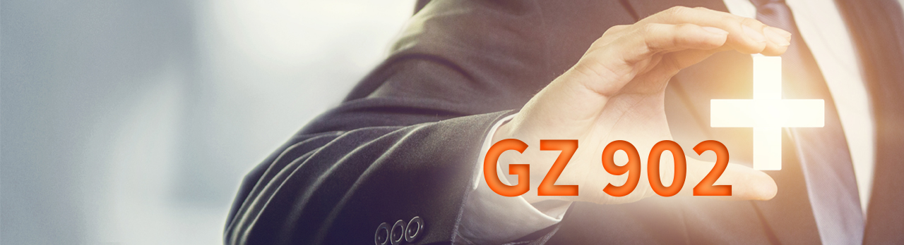 Ein Plus-Zeichen und das Wort "GZ 902" vor dem ausgestreckten Finger eines Mannes mit Anzug im Hintergrund.